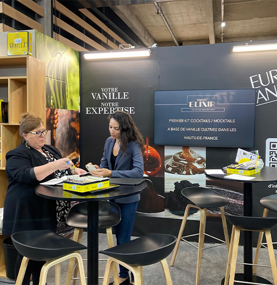 Conversation with a visitor on the Eurovanille stand at a trade show.